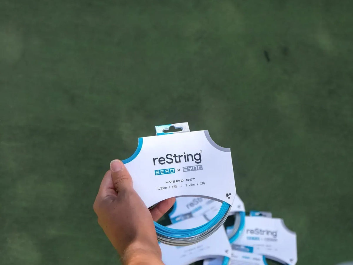 reString hybrid sets in hand on a tennis court